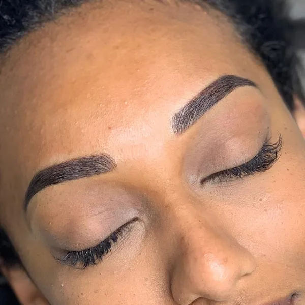 Eyebrow microblading after result — deep skin, natural hair-stroke brows