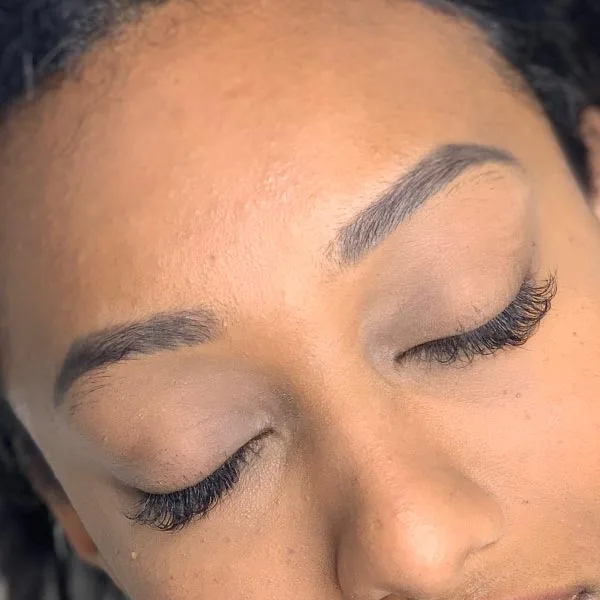 Eyebrow microblading result — deep skin tone, natural hair-stroke brows